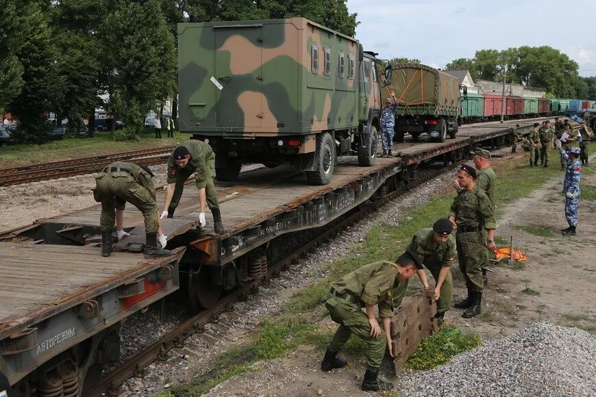 Перевозка военнослужащих. Военный камаз на железнодорожной платформе. Перевозка военнослужащих. Перевозка военнослужащих. Трал кмз военный.