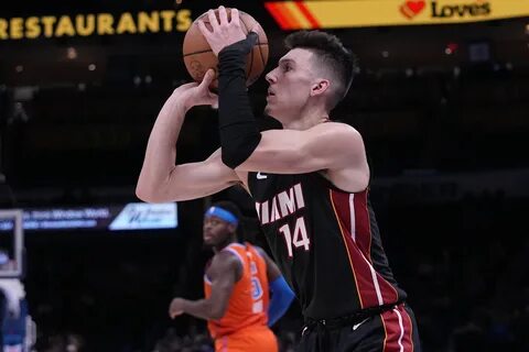 El base del Heat de Miami Tyler Herro lanza el balón frente al alero del Th...