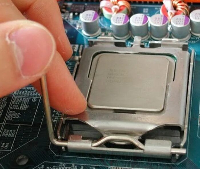 Не подключилось к сокету. Заглушка процессора lga775. Как поставить процессор на материнскую плату Intel. Снятие крышки процессора. Фиксатор процессора.