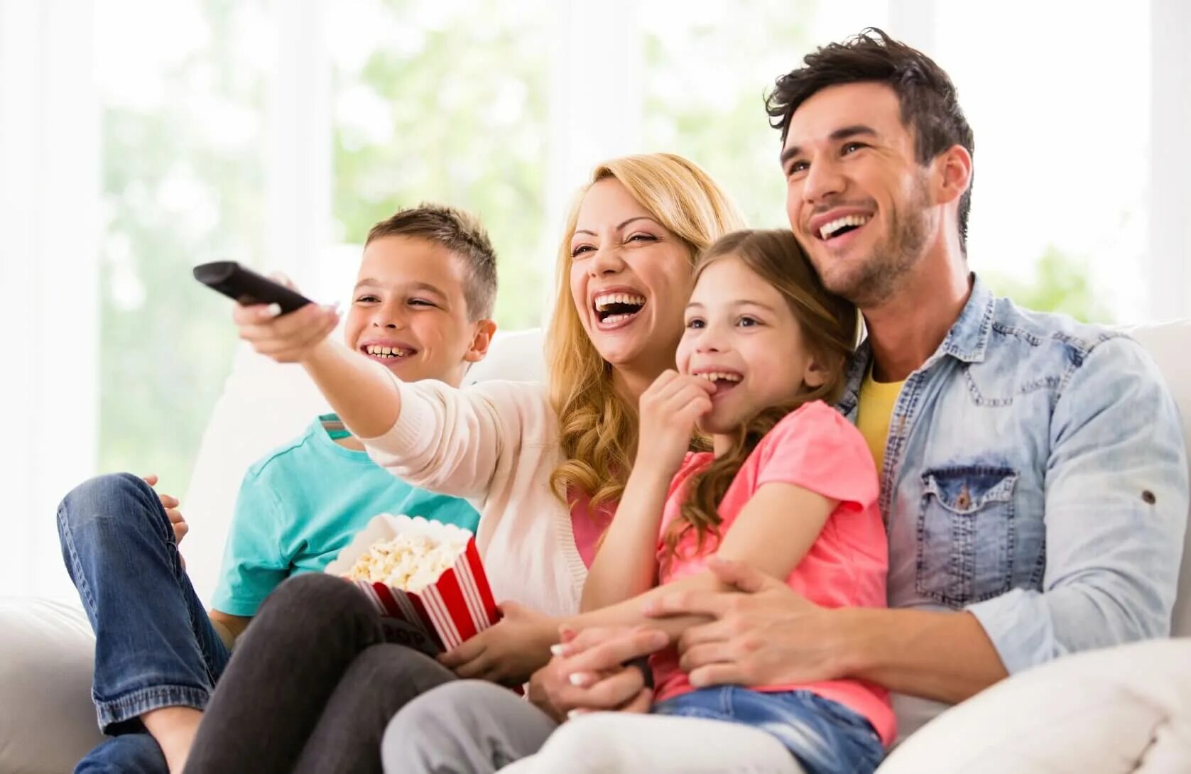 Отец смех. Семья у телевизора. Счастливая семья у телевизора. Родители и дети. Счастливый ребенок с родителями.