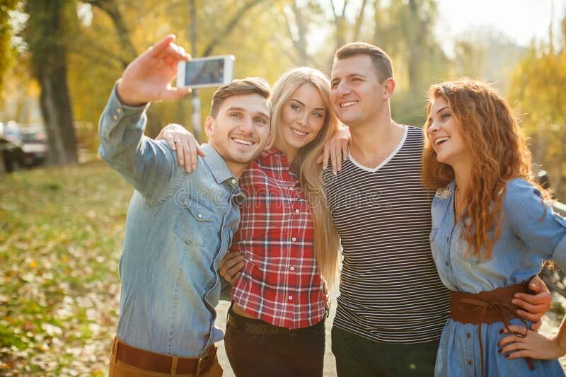 Провести друзей по городу. Друзья фотографируются. Люди фотографируют друг друга. Молодые люди фотографируются. Люди фотографируются в парке.