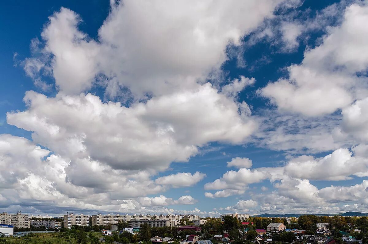 Тихо плывущие облака. Облака над городом. Облака плывут. Дневное небо. Облачность над городом.