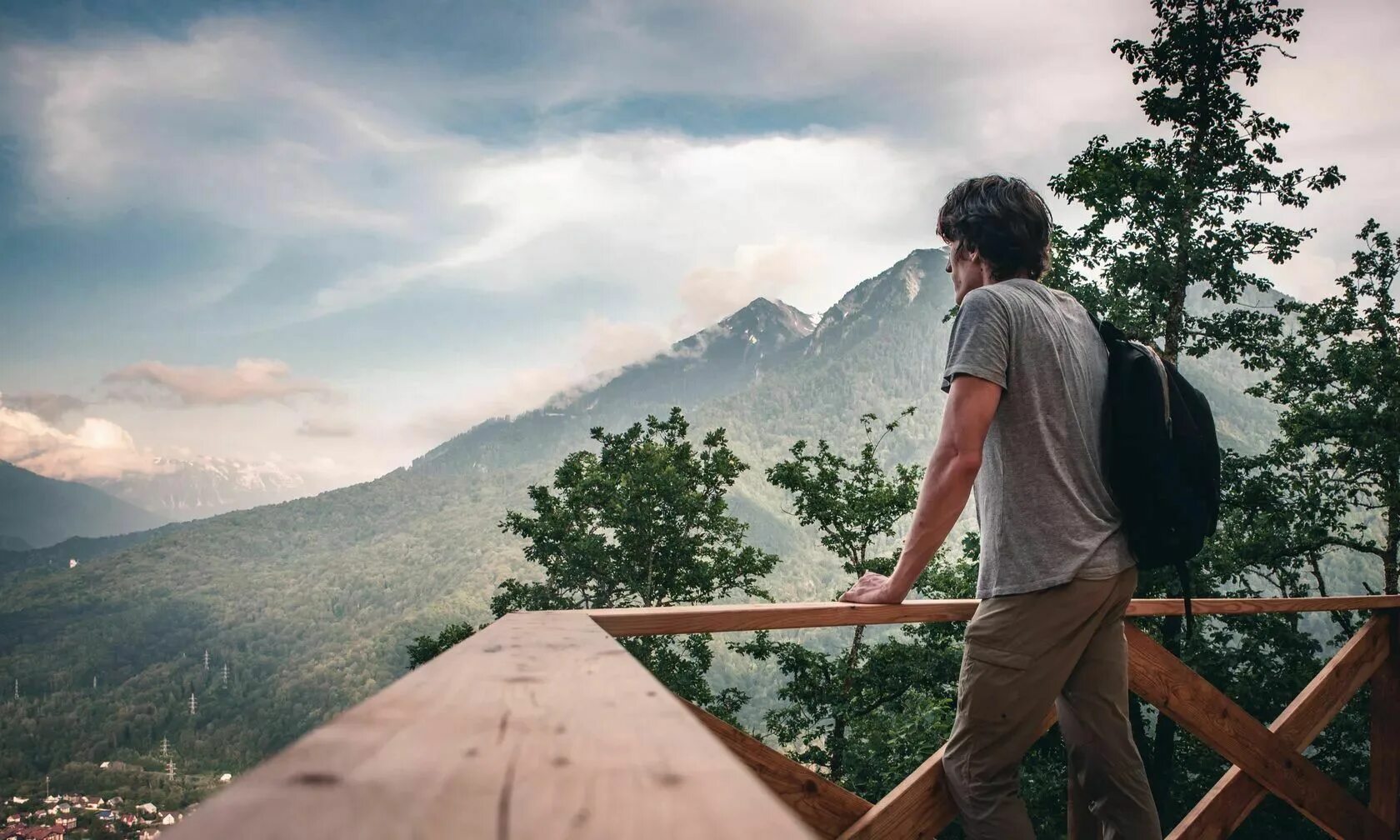Женственность природа. Парень на скале спиной. Канада альпийские луга. Он видит перед собой большую поляну. Счастливая женщина на природе.