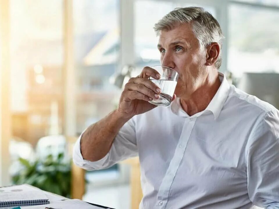 Почему советуют пить. Мужчина пьет воду. Седой мужчина. Мужчина среднего возраста. Мужчина со стаканом воды.