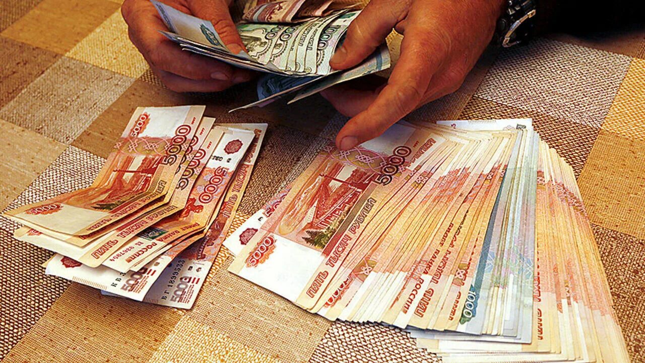 Много денег. Пачка денег. Много денег. Большие деньги на столе. Много денег.