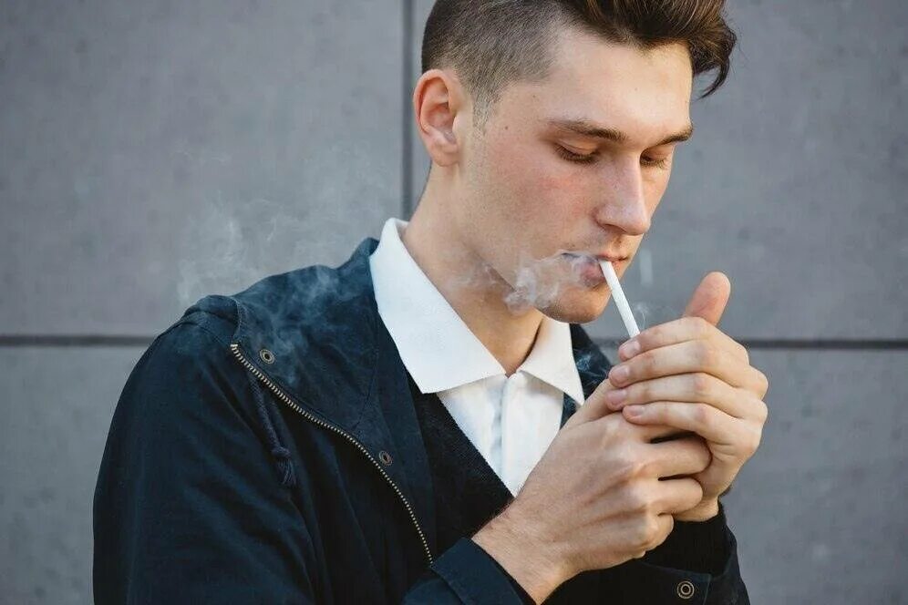 Начала курить муж. Мужчина с сигаретой на улице. Парень подкуривает сигарету. Человек идёт с сигаретой. Парень с сигаретой на улице.