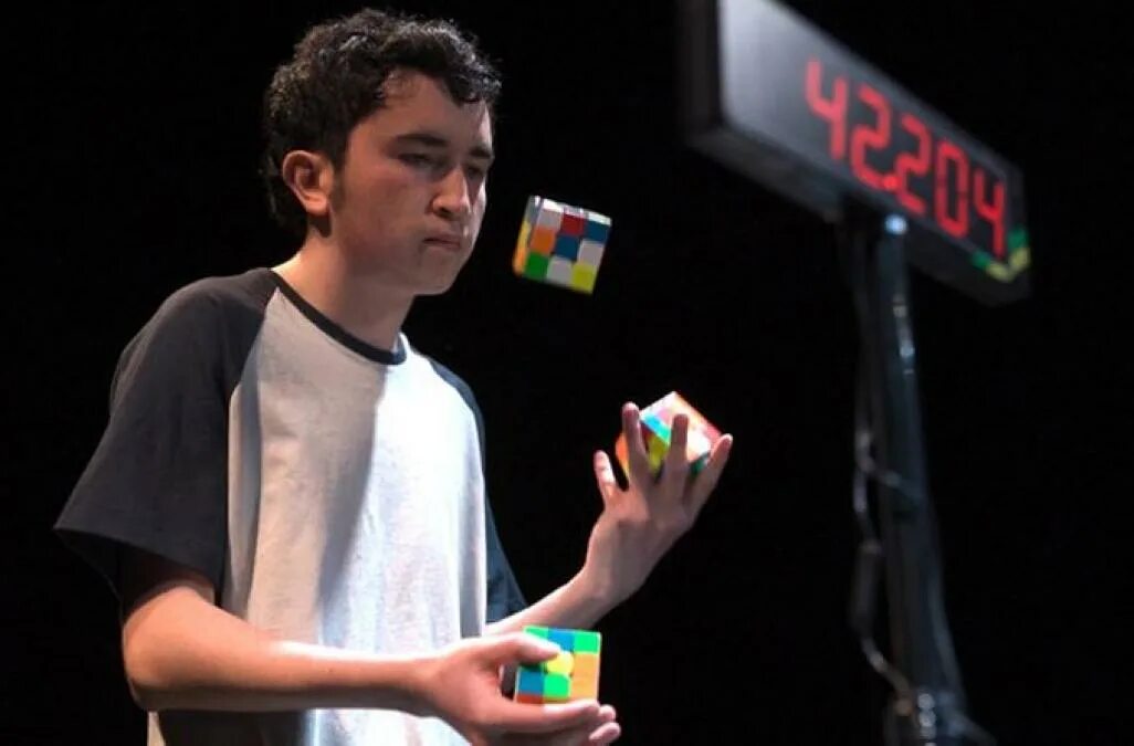 Рубик рекорд. Сборка кубика жонглируя. Мальчик собирает кубик Рубика жонглируя. Жонглирует кубиками рубиками и собирает. Человек собрал 3 кубика Рубика жонглируя ими.