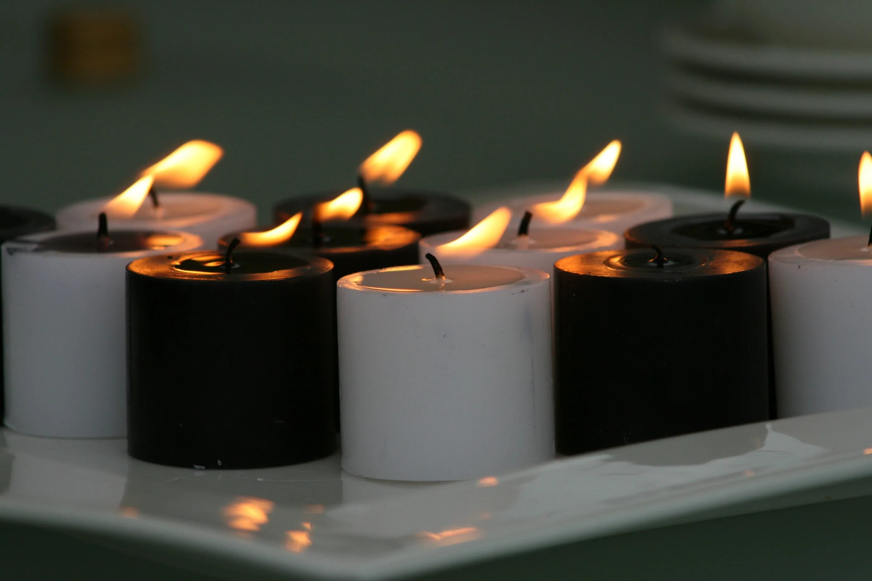 На столе стоит свеча которая отражается. Свечи. Красивые свечи. Стильные свечи. Свеча на столе.