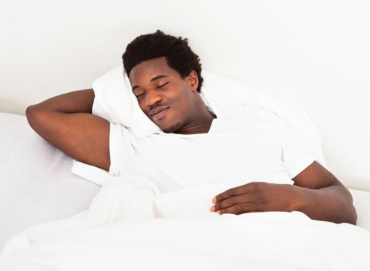 К чему снятся негры. Негр лежит. Темнокожий мужчина лежит. Негр в кровати. Афроамериканец на кровати.