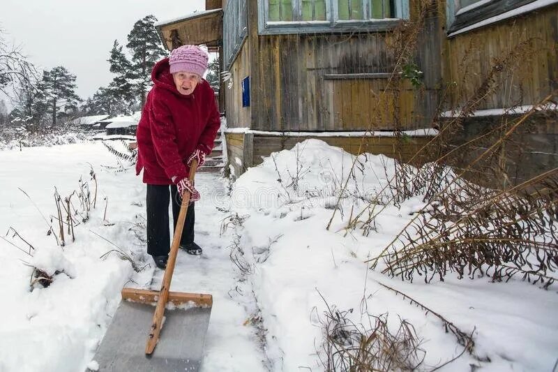 Бабушка убирает снег. Женщина убирает снег. Смешная старушка убирает снег. Деревенские бабушки дом зима. Чистить снег в деревне