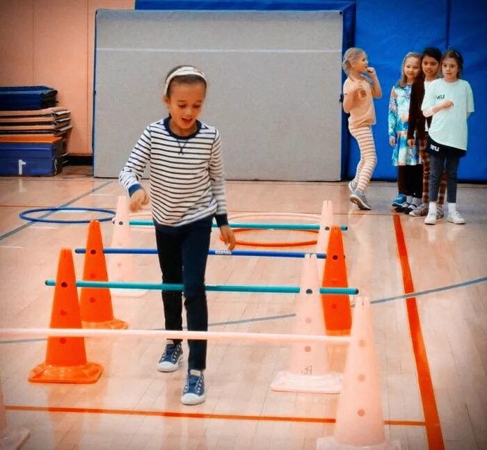перешагивает через. дорожка с препятствиями для детей. ходьба по гимнастической доске. скоростные барьеры sklz 6x. спортсмены в движении.