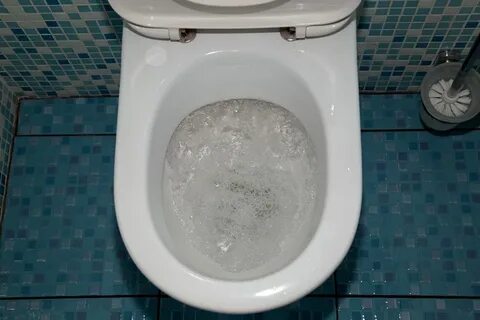 Человек смывает унитаз