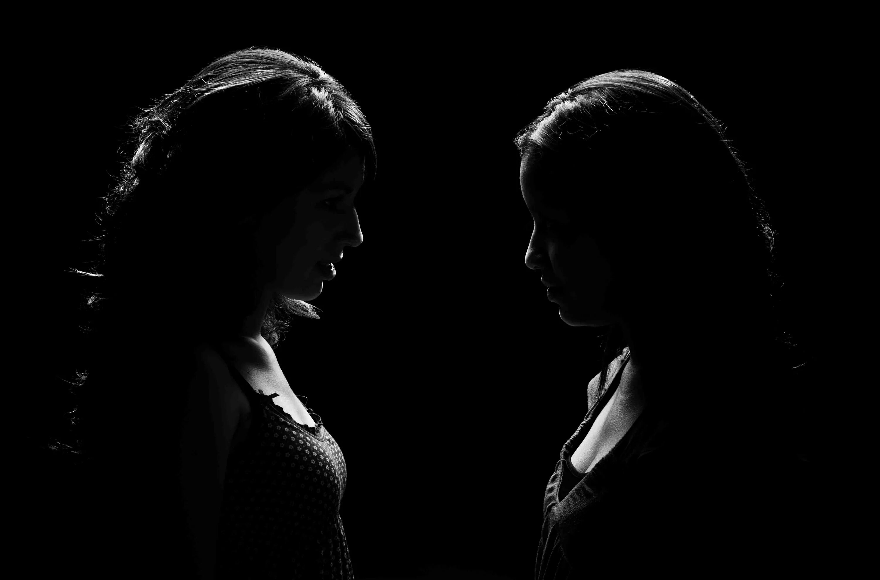 Два силуэта в темноте. Мужчина с девушкой в темноте. Ссора на черном фоне. Стоят друг напротив друга. Двое с черного входа