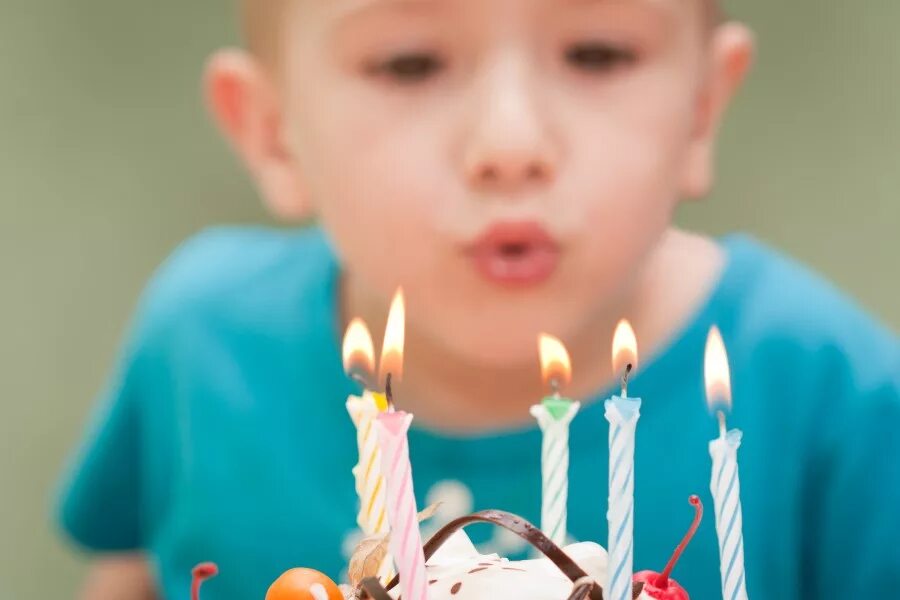 Свечку ребенку 5 лет. Мальчик задувает свечи на торте. дуть на свечу. дует свечи на торте. ребенок дует на свечку.