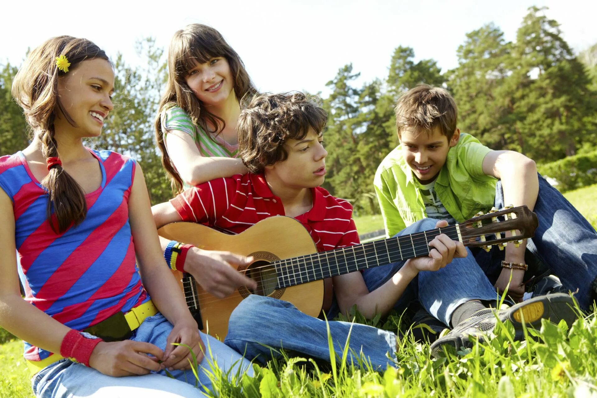 Ребята играют на гитаре. Счастливые подростки. Летний лагерь для подростков. Подростки на каникулах. Увлечения молодежи.