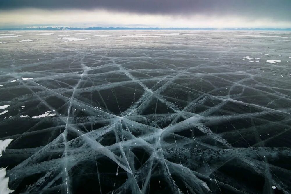 Трещины на снегу. Замерзшее озеро. Прочный лед. Треснувший лед. Трещины на льду.