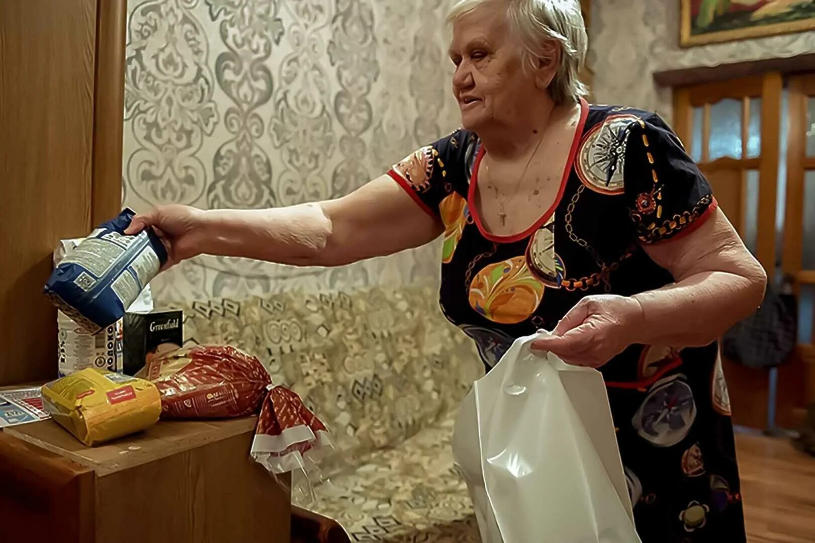 Продуктовый набор для пенсионеров. Пенсионеры с продуктами. Волонтёры продукты для пенсионеров. Пенсионерка на кухне.