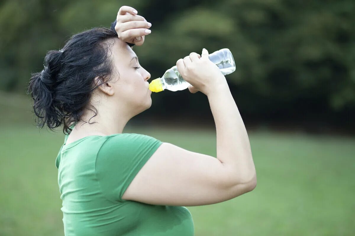 Женщина пьет воду. Толстая девушка пьет воду. Питье для похудения. Человек пьет. Стакан воды похудение