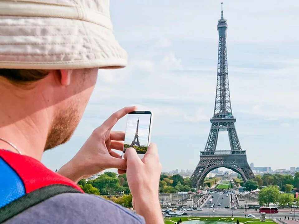 Туристы во Франции. Экскурсионный туризм во Франции. Туристы в Париже. Туристы у Эйфелевой башни.