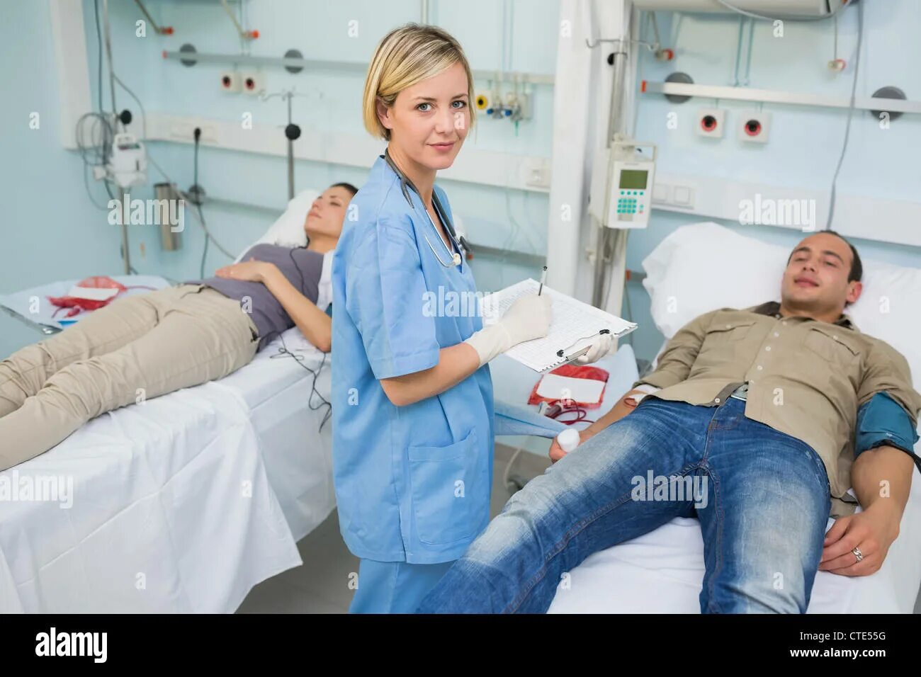 Медсестра в больнице. Медсестра и лежачий пациент. Пациент лежит. Two patients