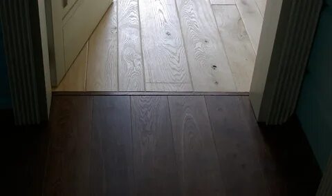 Стык напольных покрытий под дверью