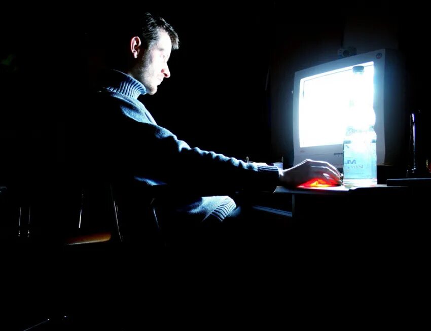 Перед экраном компьютера. Сидит за компьютером ночью. Человек сидит за компьютером ночью. За компом в темноте. Человек за компьютером.