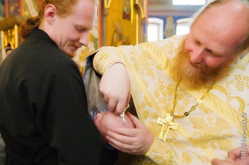 Крестины в церкви мальчика. Священник окунает ребенка. Крещение детей в церкви. Можно ли стричься на крещение ответ священника. Крещение младенца.