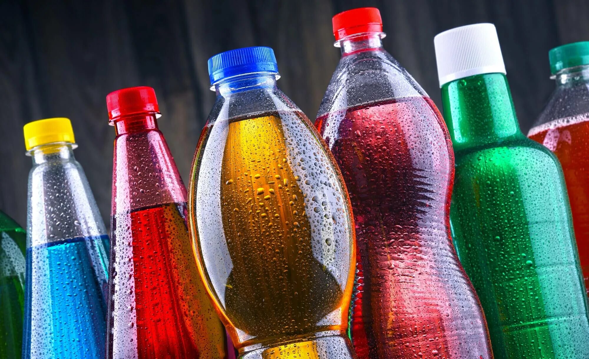 Газированные бутылки. Пластиковые бутылки газированных напитков. газировка в цветных бутылках. лимонады в пластиковых бутылках. пластиковые бутылки с газированными напитками.