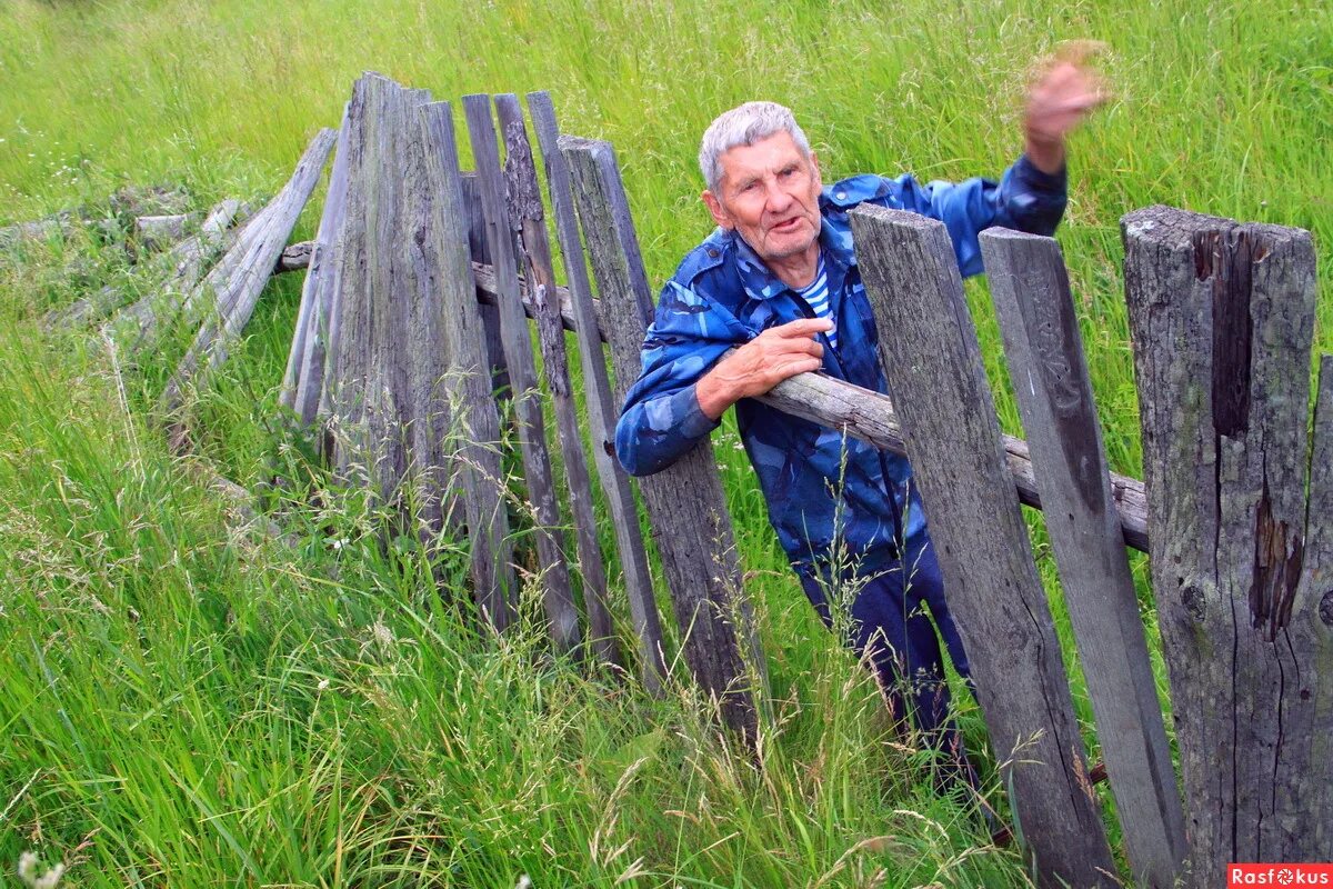 мужик красит забор. деревенский мужик. выглядывает из за забора. старики на лавочке в деревне. человек у забора.