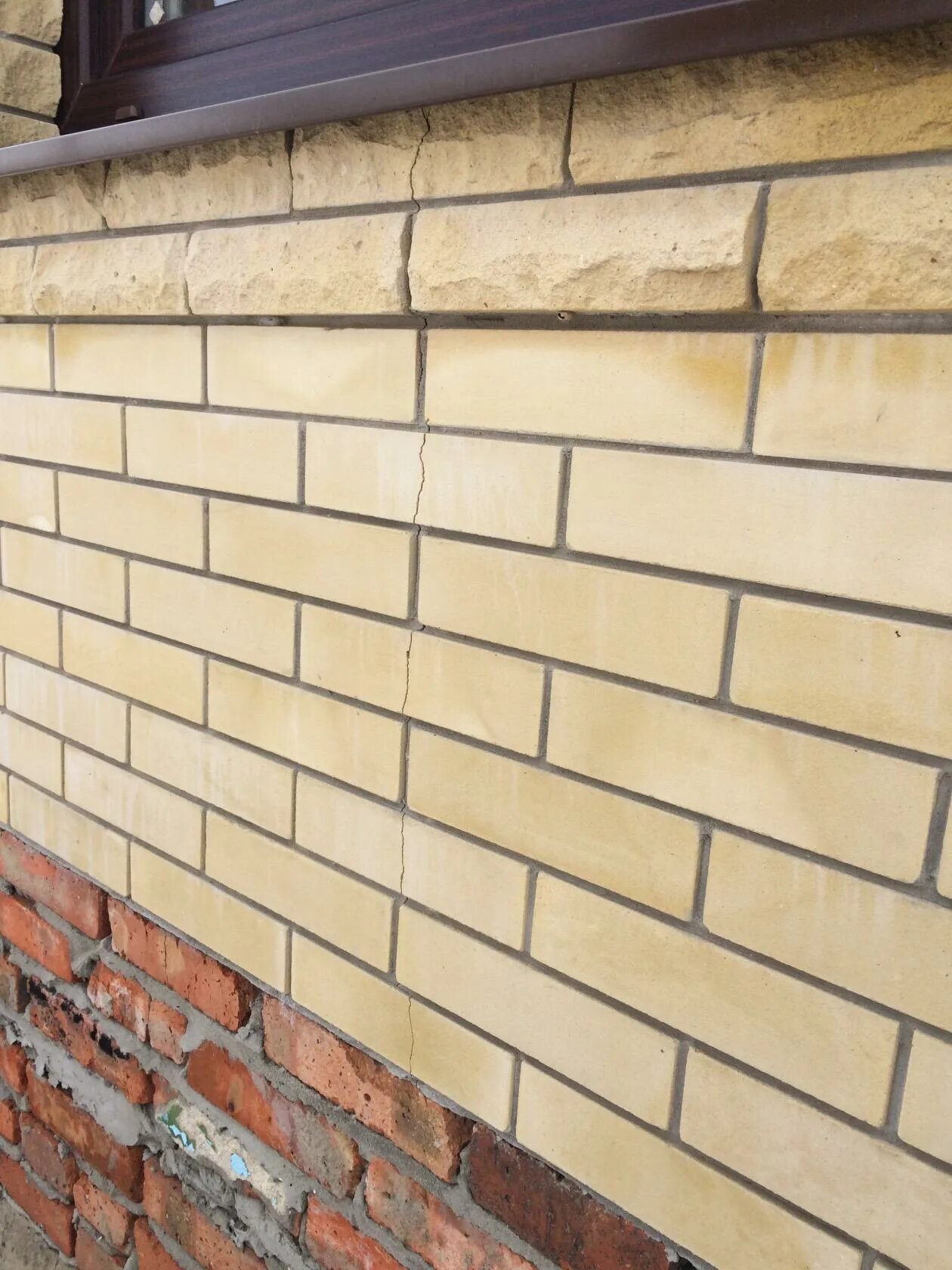 трещины в углах оконных проемов. трещина в кладке под окном. треснули под окнами. трещины на штукатурке в новостройке. трещина в стене над окном.