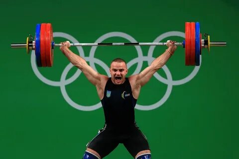 Спортсмены по тяжелой атлетике поднимают штангу