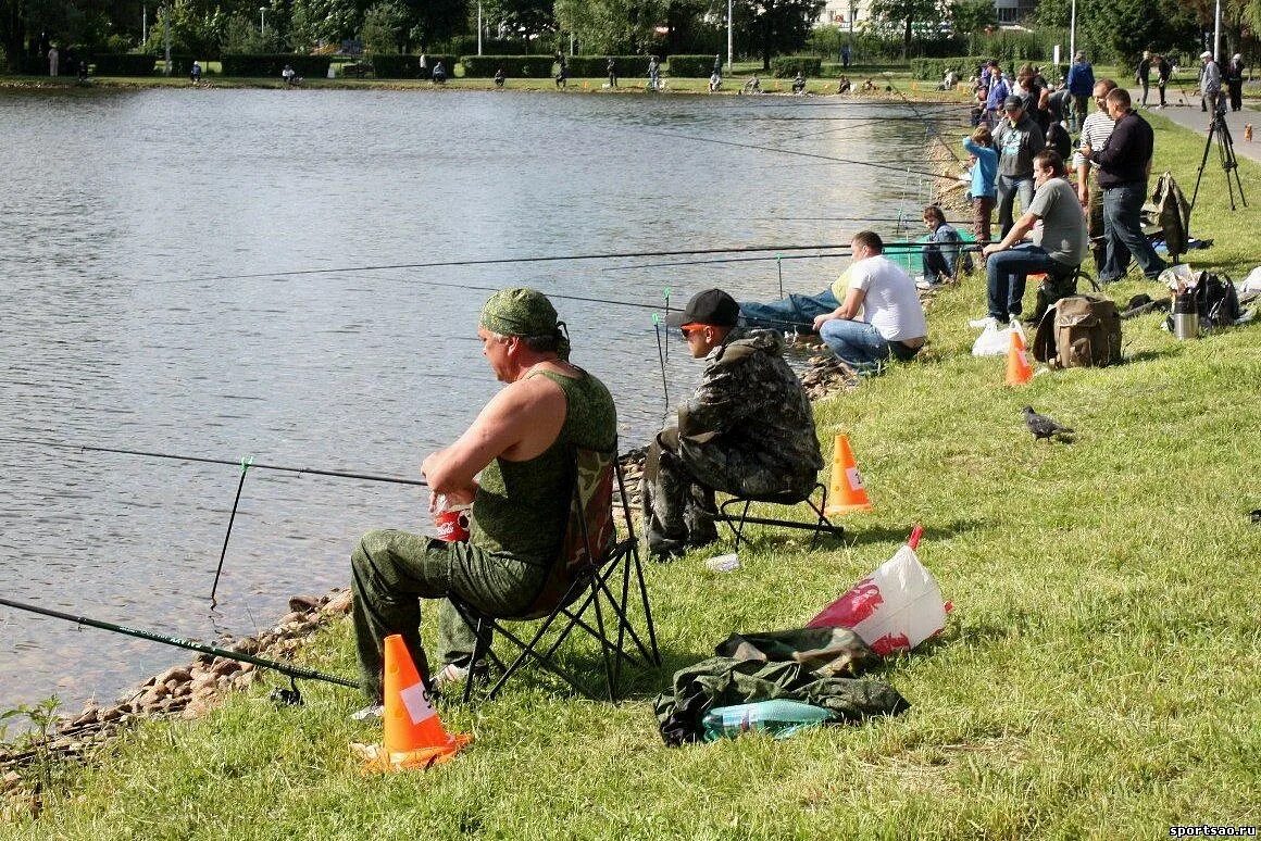 Рыбак на берегу водоема. Соревнования рыбаков. Платная рыбалка. Рыбалка летом. Соревнования по рыбной ловле.