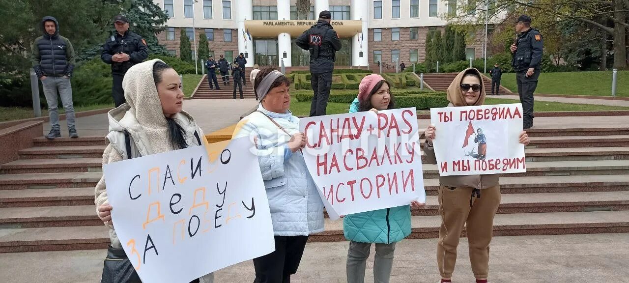 Жива ли бабушка с флагом на украине. Человек с плакатом. Парламент Молдовы Георгиевская лента. Георгиевская лента в Молдове. Бабки с плакатом.