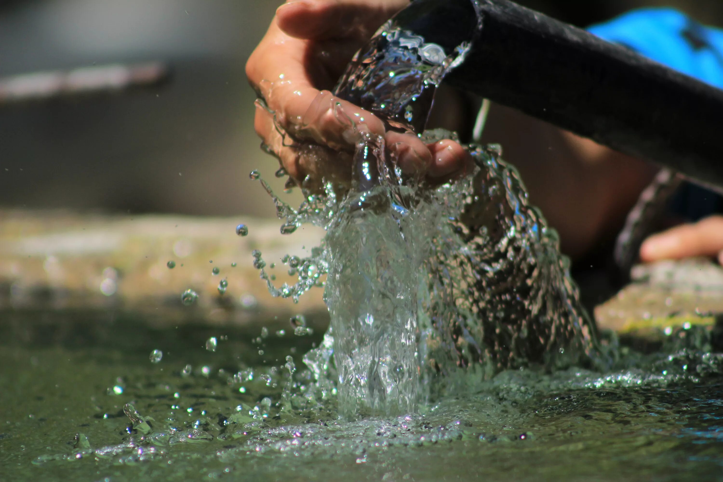 Вода в руках. Брызги воды. Вода льется. Черпать воду.