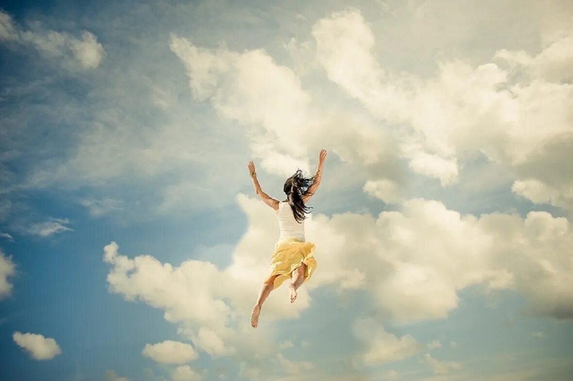 Девушка в прыжке. Полет в облаках. Девушка парит в небе. Девушка в полете.