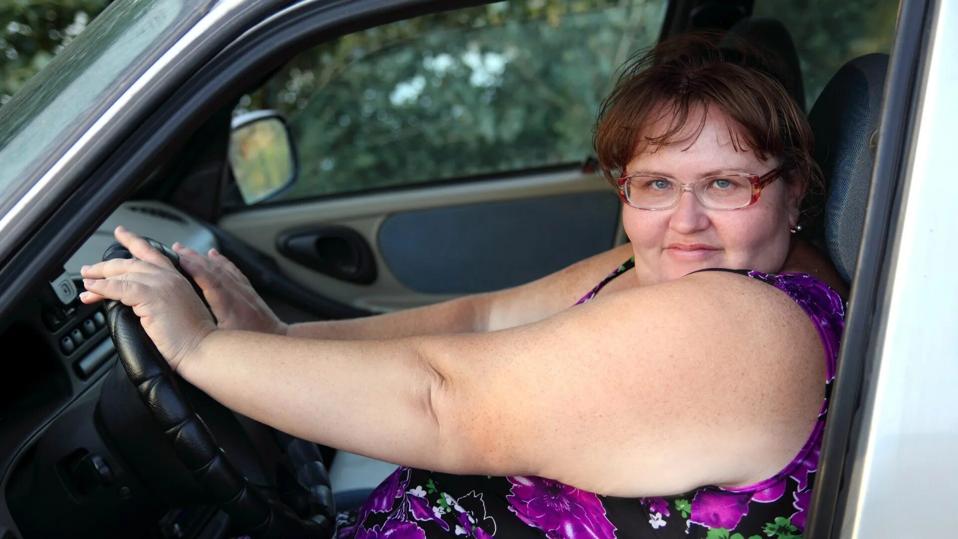 Полная женщина в машине. Толстая в авто.