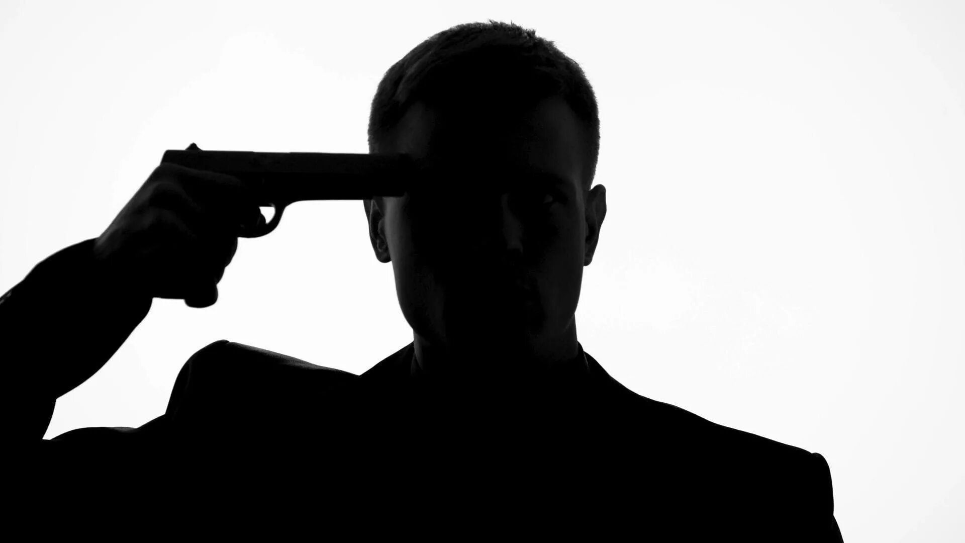 Человек стреляет себе в голову. Пистолет к виску. Мужчина хочет застрелиться. Человек с пистолетом у вика. Хочу застрелить человека.