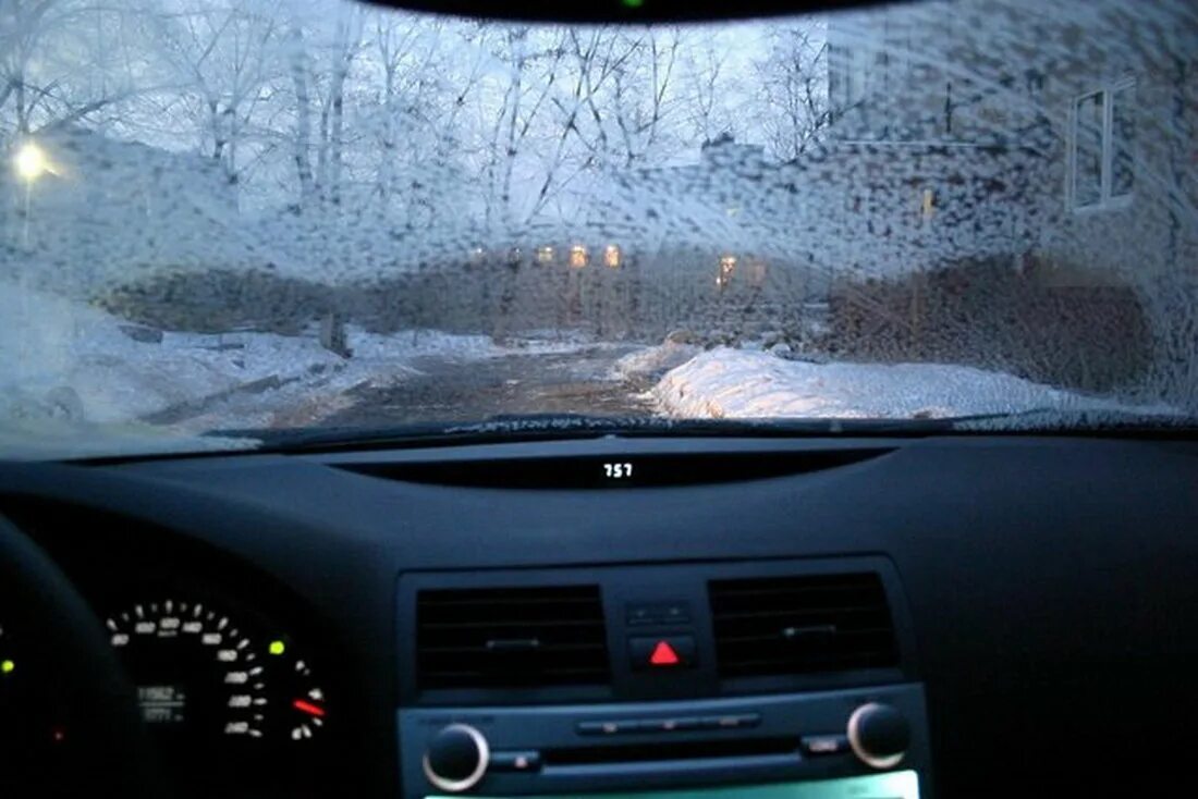 Зимой стекла движущегося автомобиля могут запотеть. Лобовое стекло машины изнутри. лобовое окно машины. замерзшее лобовое стекло изнутри. в салоне машины зимой.