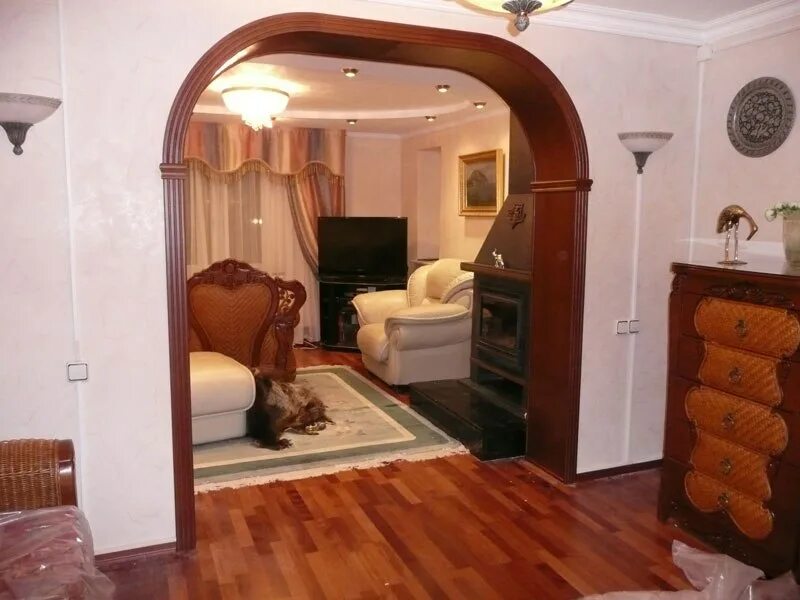 Декоративные арки из гипсокартона. Арка в комнате. Перегородка из гипсокартона для зонирования комнаты. Стеллаж у стены в арке. Арка в комнате.