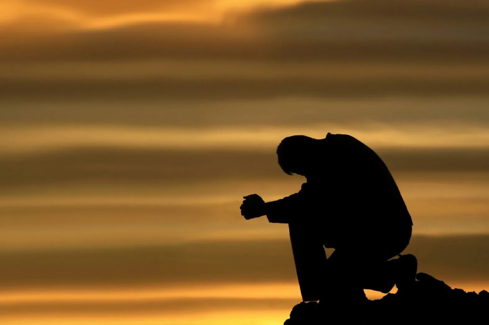 Человек молится на коленях. Размышления о жизни. Одинокий мусульманин. Силуэт молящегося человека. Размышления о боге