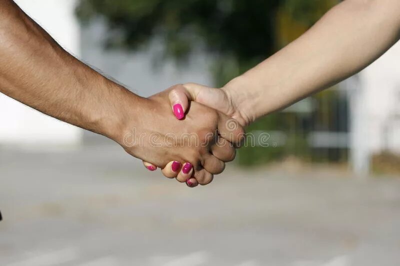 Друзья детства улыбнувшись пожали друг. Пожатие рук мужчины и женщины. Пожатие рук девушки и парня. Девушки пожимают руки. Дружеское рукопожатие мужчины и женщины.