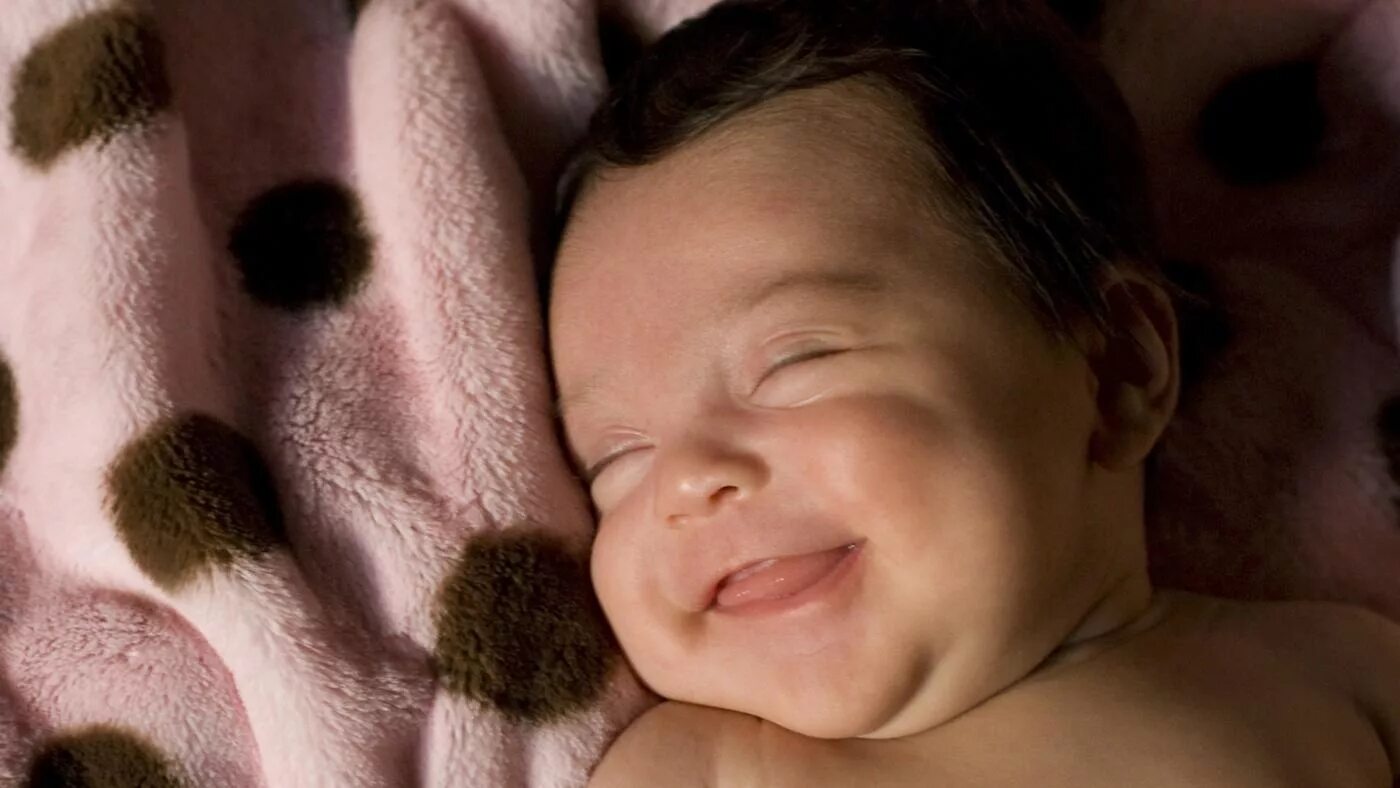 Смеяться во сне к чему это. Ребенок улыбается во сне. Малыш смеется во сне. Улыбки спящих малышей. Младенец смеется во сне.