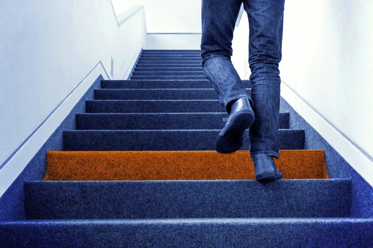 Мужчина поднимается по лестнице. Человек поднимается по лестнице. Парень поднимается по лестнице. Ткань по ступенькам. Самый крепкий материал по лестнице.