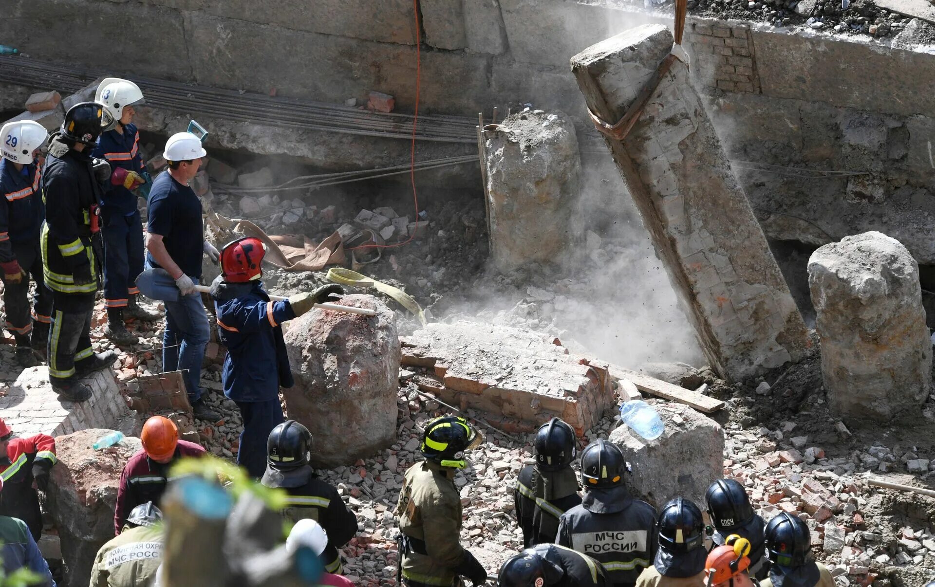 Спасатели разбирают завалы. Спасатели на обрушении здания.