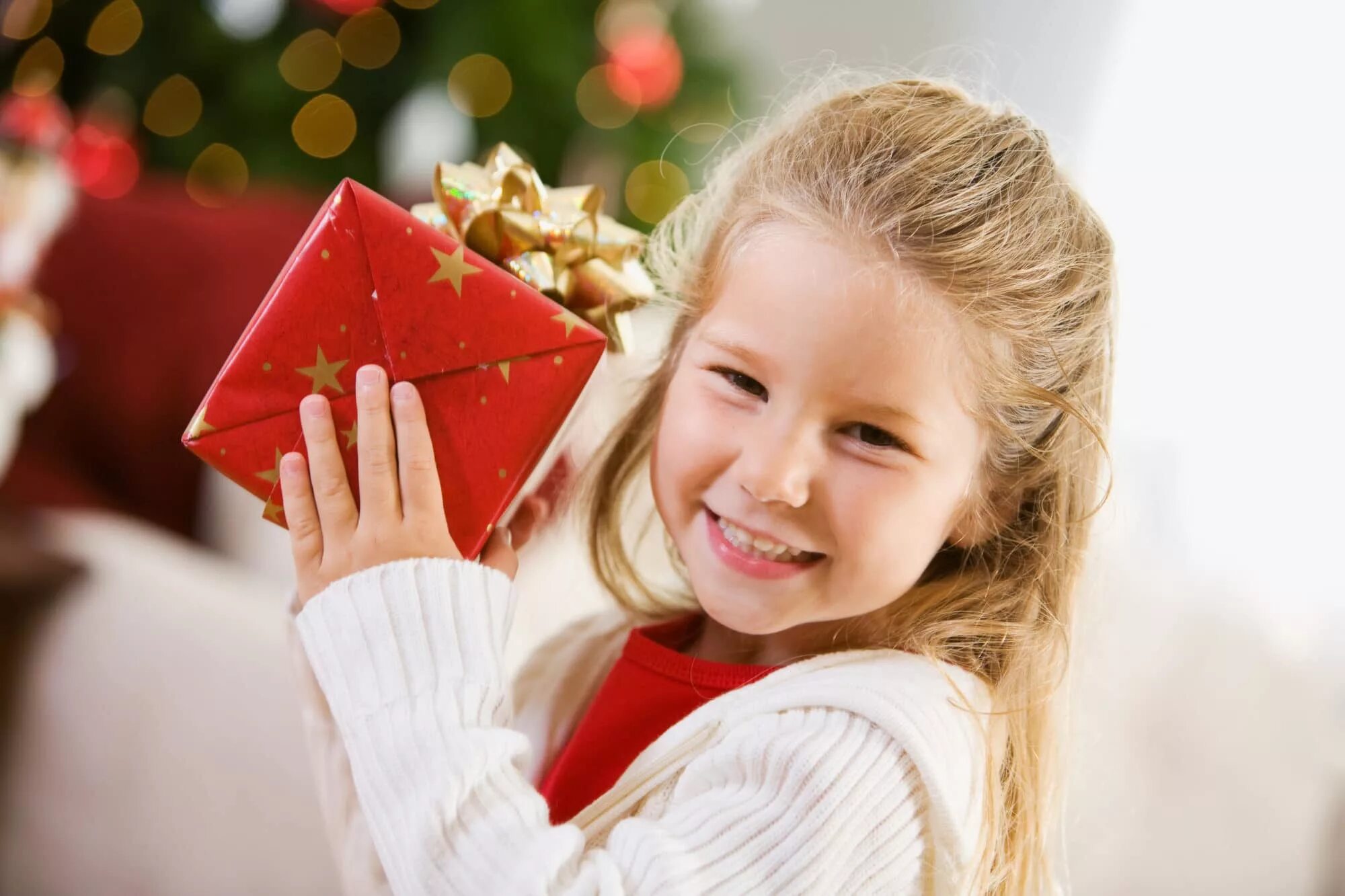 Новогодние подарки для детей. Подарок для девочки. Счастливый ребенок с подарком. Ребенок дарит подарок.