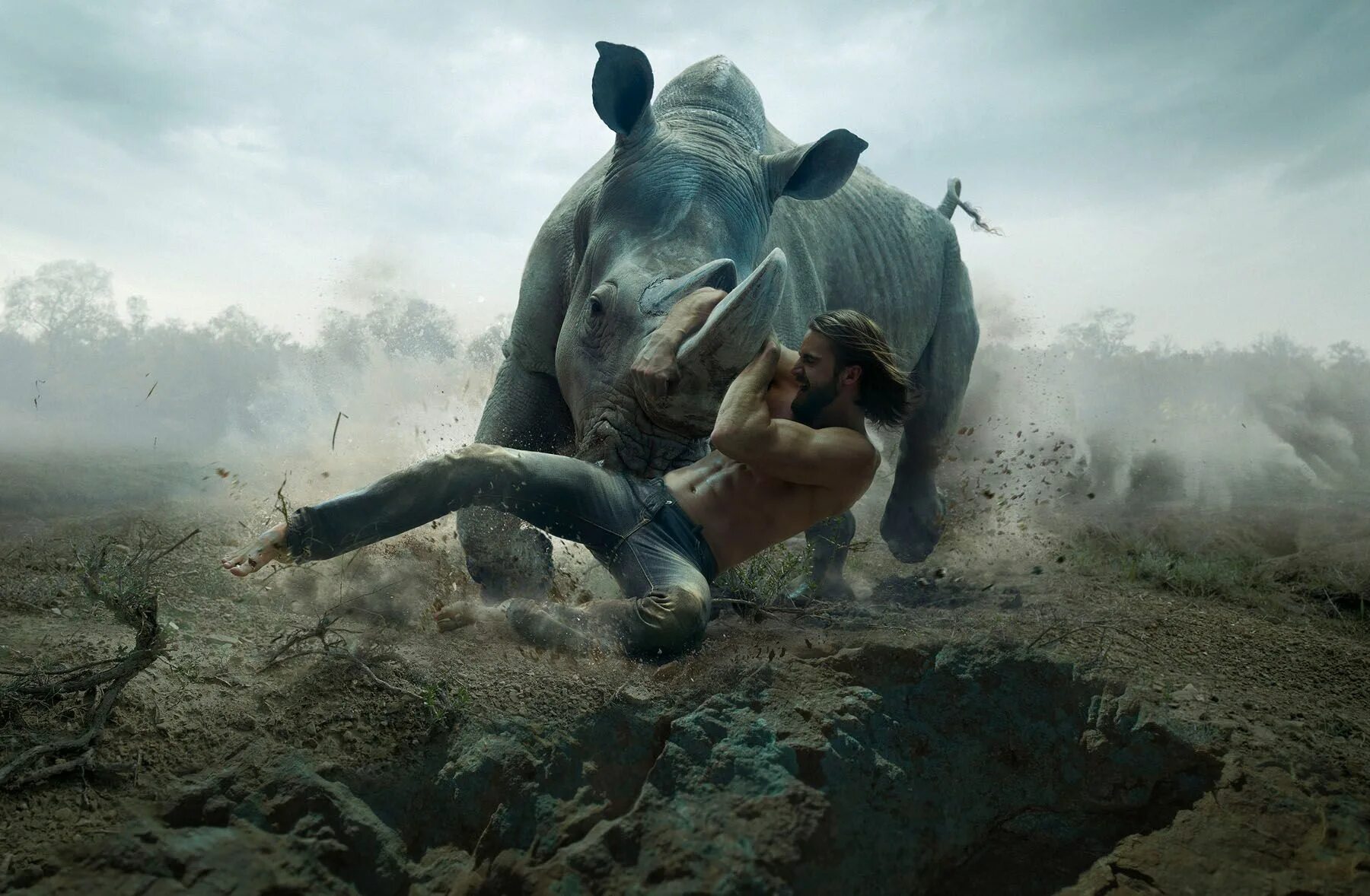 Монстр гонится. Носорог бежит. Разъяренный носорог. Человек верхом на носороге.