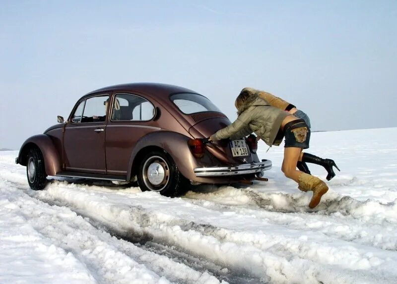 Женщина застряла в машинке. Машина в снегу. Толкают машину в снегу. Девушки толкают машину зимой. Девушка толкает авто.