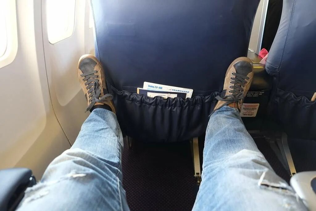 Пить перед полетом. Ступни в самолете. Ноги мужские в самолете. Автобус с ногами. Ноги на сиденье.