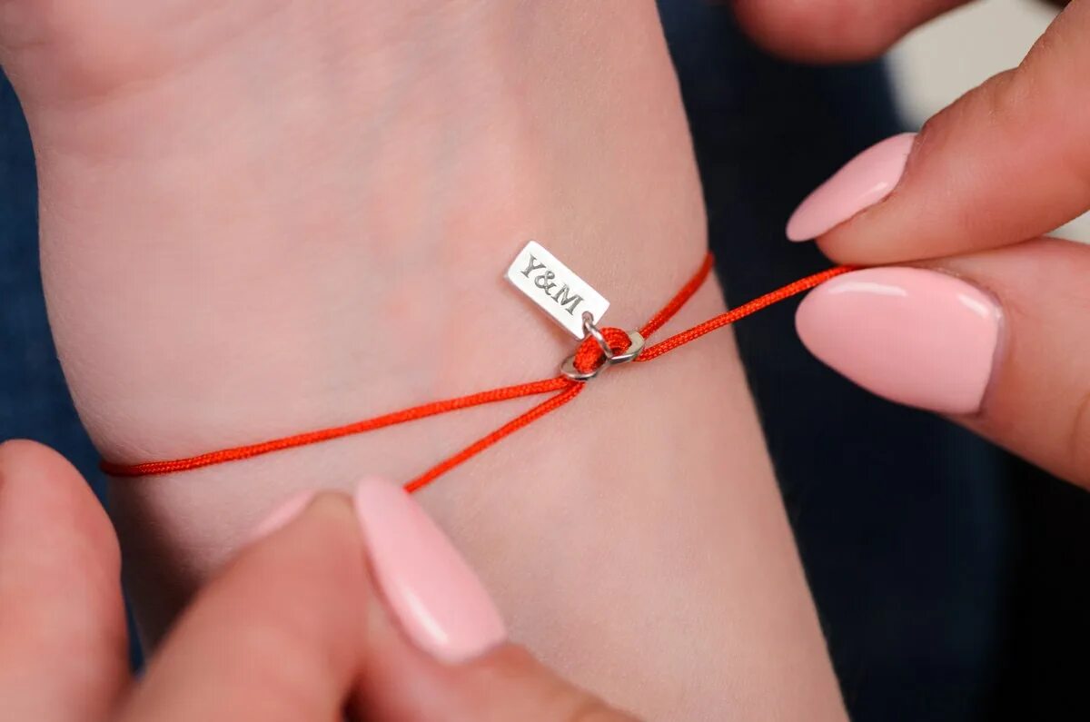 красные ниточки на ногах. знаки зодиака на красной нити. люди с красной ниткой на руке. на животике беременной ленточка. браслет знак бесконечности.
