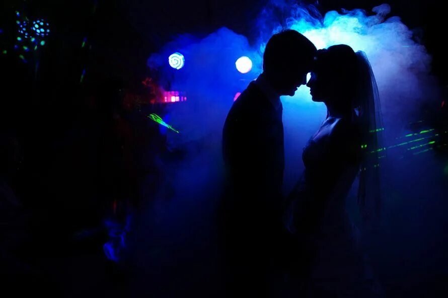 Медляк в темноте. Свадьба силуэт в дыму. Медляк пара. Световой голубой профиль.